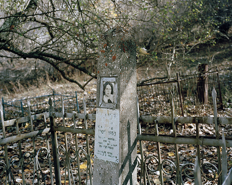 A Soviet grave with a picture of a woman. An old and forgotten cemetery is situated on the other side of the Kattasay stream than the city. Most of the inhabitants of Yangiabad and workers of the mines were people from Russia.